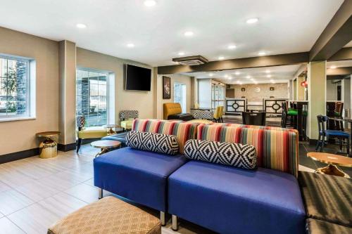 un soggiorno con un divano blu in una stanza di Comfort Inn Memphis Airport West a Memphis