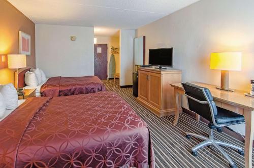 a hotel room with two beds and a desk at Econo Lodge Inn & Suites in Norton