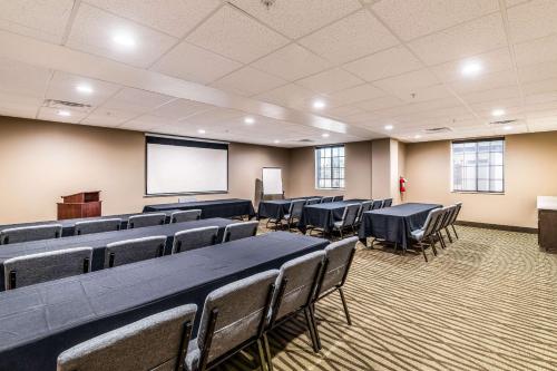 a conference room with tables and chairs and a screen at Comfort Suites Grand Prairie - Arlington North in Grand Prairie