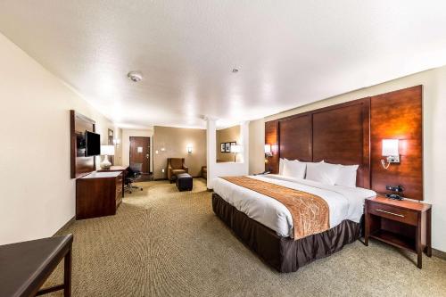 Habitación de hotel con cama grande y escritorio. en Comfort Suites Grand Prairie - Arlington North en Grand Prairie