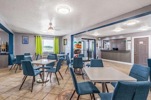 a waiting room with tables and chairs and a kitchen at Quality Inn I-10 East near Frost Bank Center in San Antonio