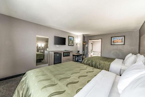 a hotel room with two beds and a television at Quality Inn I-10 East near Frost Bank Center in San Antonio