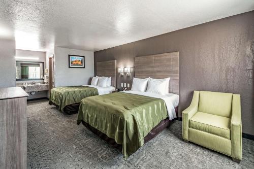 ein Hotelzimmer mit 2 Betten und einem Stuhl in der Unterkunft Quality Inn I-10 East near Frost Bank Center in San Antonio