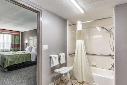 a hotel room with a bathroom with a bed and a tub at Quality Inn I-10 East near Frost Bank Center in San Antonio