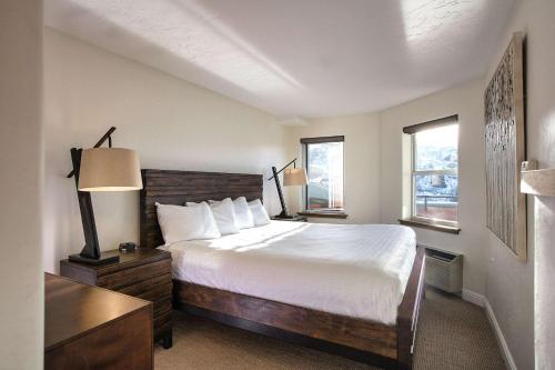 1 dormitorio con 1 cama, escritorio y 2 ventanas en The Inn at Riverwalk, en Edwards