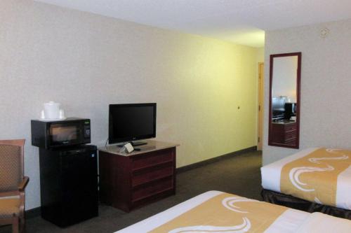 a hotel room with two beds and a tv and a room at Quality Inn & Suites Downtown - University Area in Albuquerque