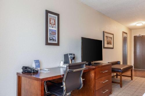 a room with a desk with a computer and a television at Comfort Inn South Tulsa - Woodland Hills in Tulsa