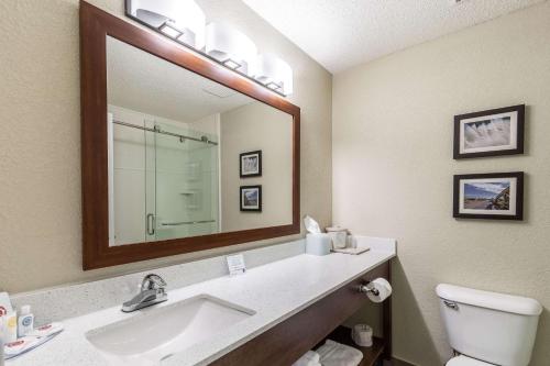 a bathroom with a sink and a mirror at Comfort Inn South Tulsa - Woodland Hills in Tulsa