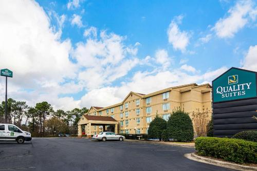 a hotel with a car parked in front of a building at Quality Suites Atlanta Airport East in Forest Park