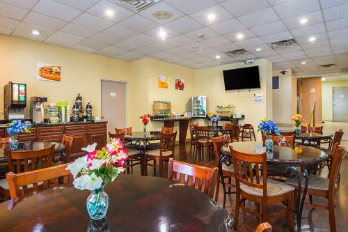 a restaurant with tables and chairs with flowers on them at Quality Suites Atlanta Airport East in Forest Park