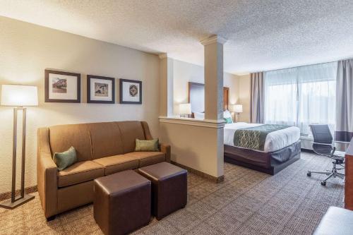 a hotel room with a bed and a couch at Comfort Inn South Tulsa - Woodland Hills in Tulsa