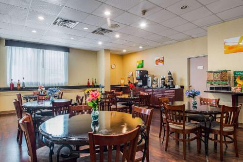 Un comedor con mesas y sillas en un restaurante. en Quality Suites Atlanta Airport East, en Forest Park
