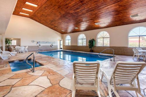 a pool in a house with chairs around it at Quality Inn & Suites Albuquerque North near Balloon Fiesta Park in Albuquerque