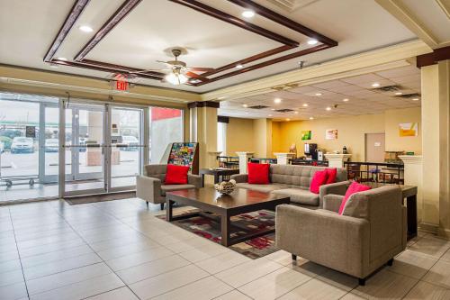 a lobby with couches and a table in a building at Quality Suites Atlanta Airport East in Forest Park