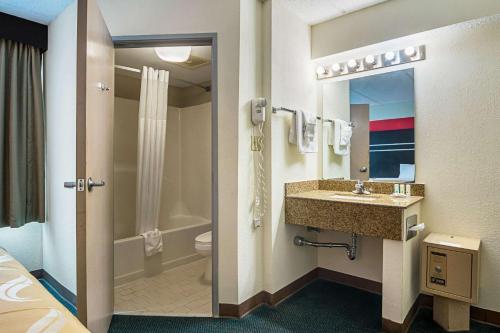a hotel bathroom with a sink and a toilet at Quality Suites Atlanta Airport East in Forest Park
