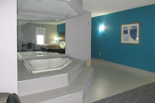 uma casa de banho com uma banheira e uma parede azul em Quality Inn & Suites 