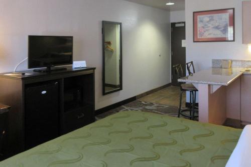 Habitación de hotel con cama y TV de pantalla plana. en Quality Inn Spanish Fork North, en Spanish Fork