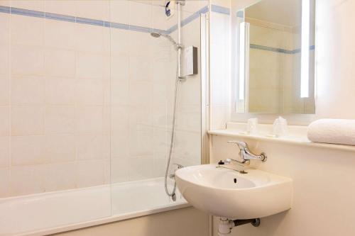 a white bathroom with a sink and a shower at Comfort Hotel Lens - Noyelles Godault in Noyelles-Godault