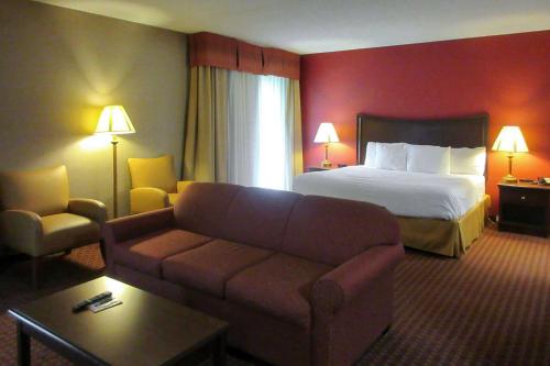 a hotel room with a bed and a couch at Quality Inn & Suites Owego in Owego