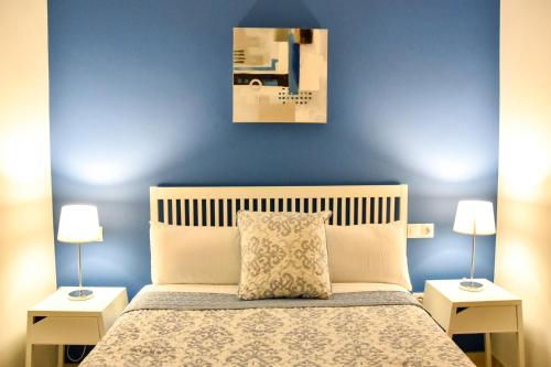 セビリアにあるAlohaMundi Moratinの青い壁のベッドルーム1室、ベッド1台(ランプ2つ付)