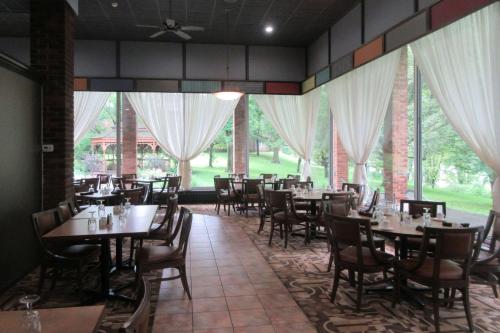 - une salle à manger avec des tables, des chaises et des fenêtres dans l'établissement Quality Inn & Suites Owego, à Owego