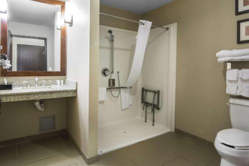 uma casa de banho com um chuveiro, um WC e um lavatório. em Comfort Suites Saskatoon em Saskatoon