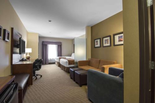 a hotel room with a couch and a bed at Comfort Suites in Saskatoon
