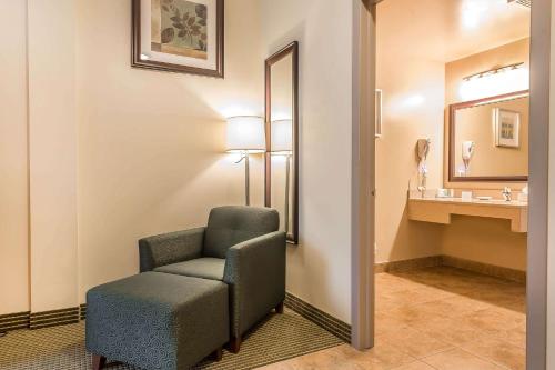 a bathroom with a chair and a sink at Quality Inn & Suites in Hawkesbury
