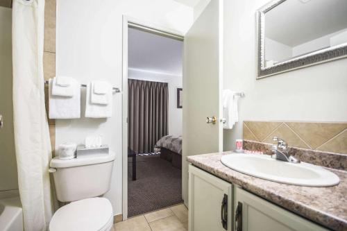 a bathroom with a toilet and a sink at Econolodge Vernon in Vernon