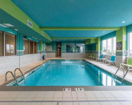 a large swimming pool in a hotel with chairs around it at Comfort Inn & Suites Airport North in Calgary