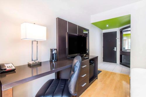 a desk with a television and a chair in a room at Travelodge by Wyndham Trois-Rivieres in Trois-Rivières