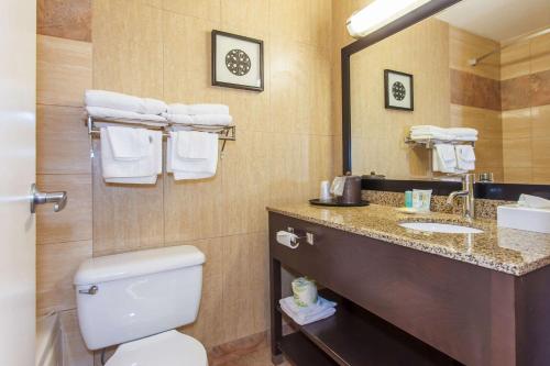 a bathroom with a toilet and a sink and a mirror at Quality Inn Merritt in Merritt