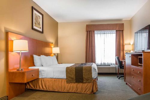 a hotel room with a bed and a window at Quality Inn & Suites in Hawkesbury