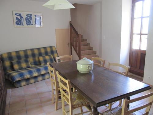 a dining room with a table and chairs and a couch at Le Mas des Restanques in Le Poët-Laval