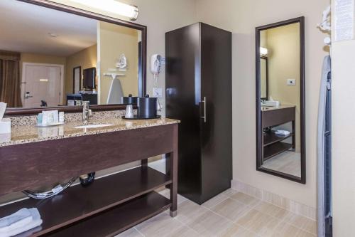 een badkamer met een wastafel en een grote spiegel bij Quality Inn Merritt in Merritt