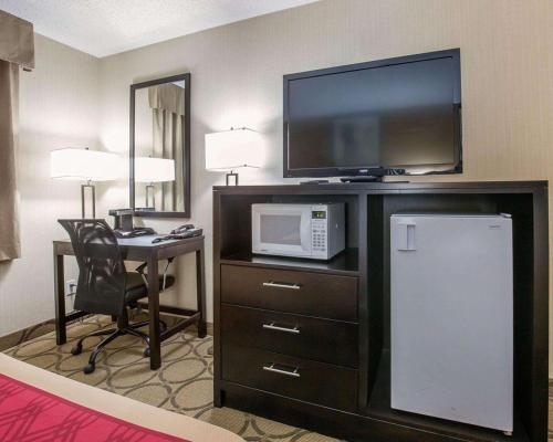 a hotel room with a television and a desk with a microwave at Econo Lodge Taber in Taber