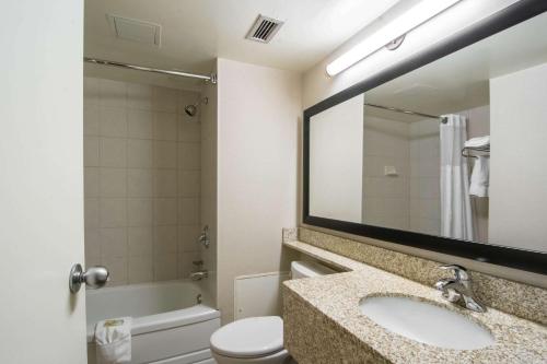 a bathroom with a sink and a toilet and a mirror at Quality Inn & Suites Yellowknife in Yellowknife