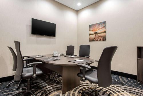 a conference room with a table with chairs and a flat screen tv at Clarion Hotel & Suites in Brandon