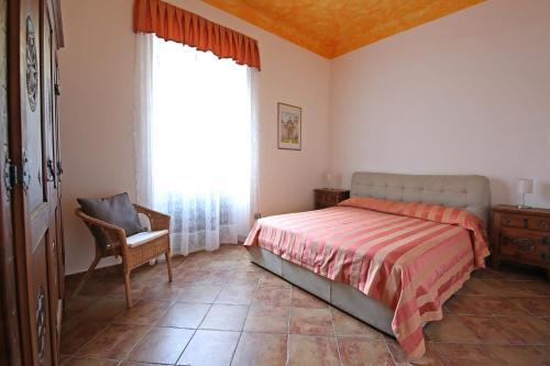 a bedroom with a bed and a chair and a window at Mella Bellagio Rosa Dei Venti - Elegante appartamento nel cuore di Bellagio con parcheggio privato in Bellagio