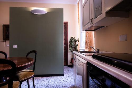 a kitchen with a table and a sink and a counter at Casa Costa Classica in Genova