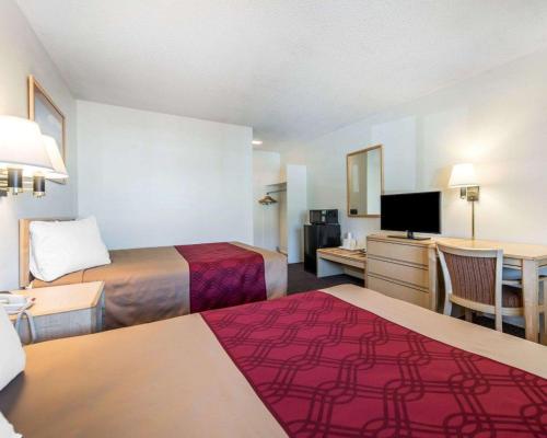 a hotel room with two beds and a flat screen tv at Econo Lodge Colorado Springs Downtown in Colorado Springs