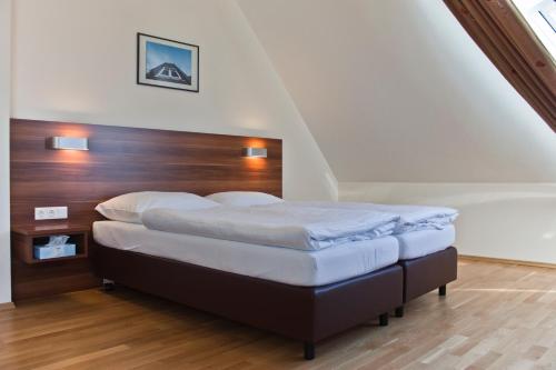 1 dormitorio con 1 cama con cabecero de madera en Sky Apartments Vienna, en Viena