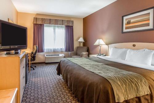 ラブランドにあるQuality Inn & Suites Lovelandのベッド1台、薄型テレビが備わるホテルルームです。