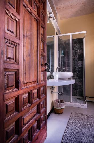 a bathroom with a wooden door and a sink at Casa Costa Classica in Genoa