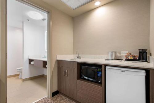 a kitchen with a sink and a microwave at Clarion Hotel & Suites in Brandon