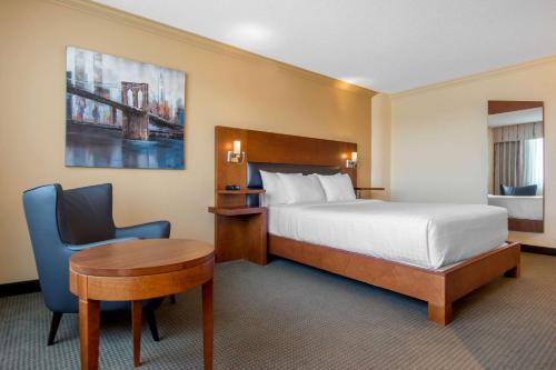 a hotel room with a bed and a desk and a chair at Quality Hotel Centre de Congrès in Saint-Jean-sur-Richelieu