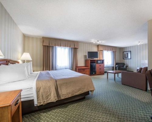 Habitación de hotel con cama y sala de estar. en Quality Inn Airport en Colorado Springs