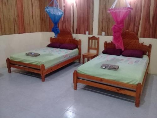 duas camas num quarto com duas cadeiras em Cabaña Hach Winik em Ocosingo