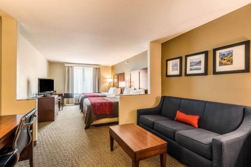 a hotel room with a couch and a bed at Comfort Inn & Suites Rifle in Rifle