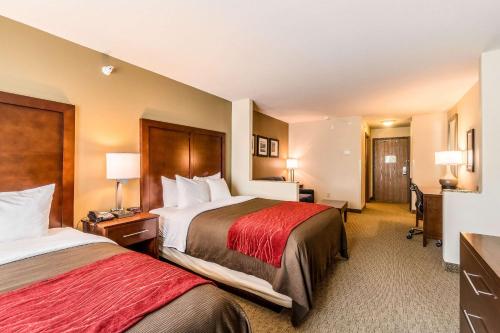 a hotel room with two beds and a desk at Comfort Inn & Suites Rifle in Rifle